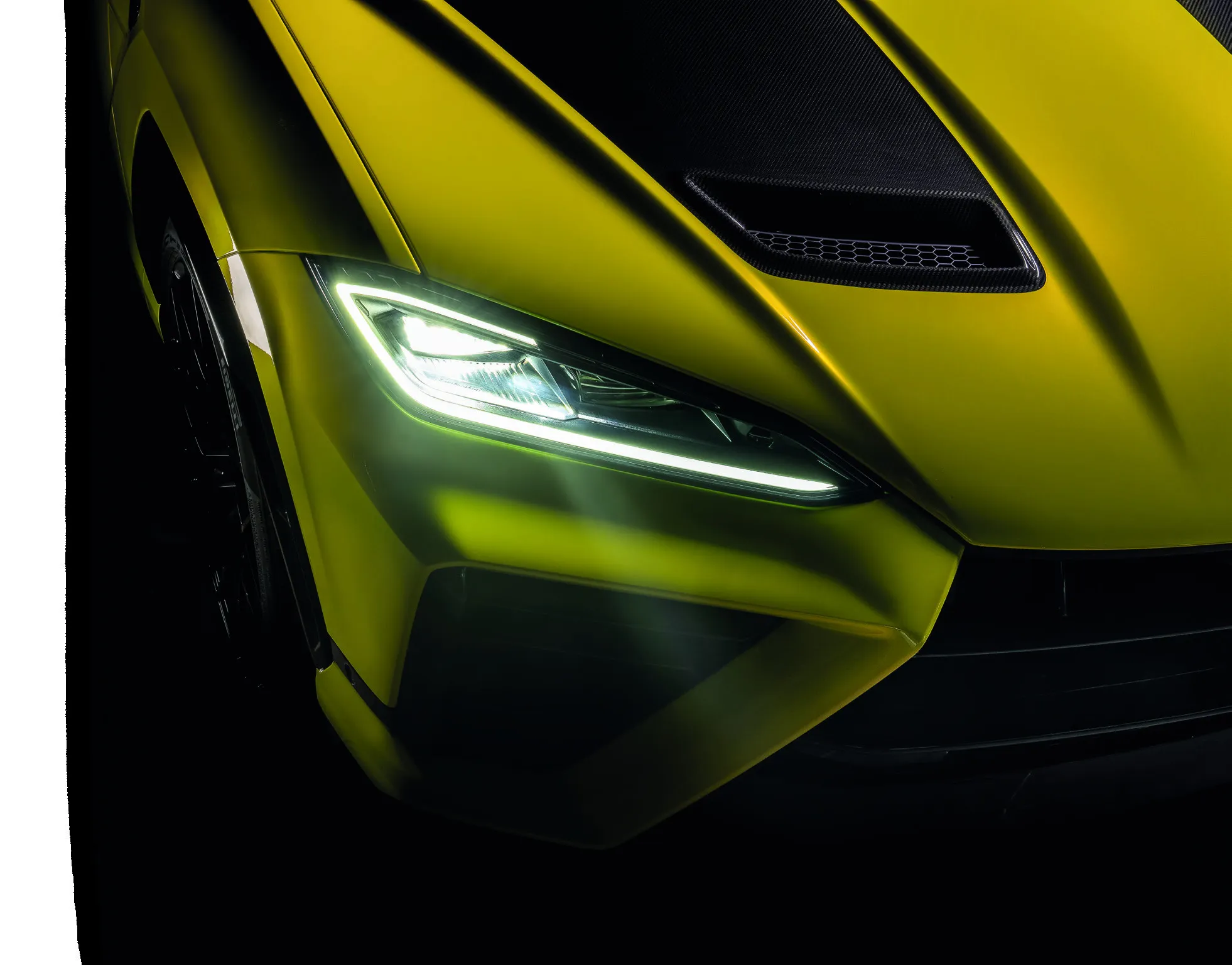 Headlight and carbon-fibre front intake of a yellow Urus SE Performante